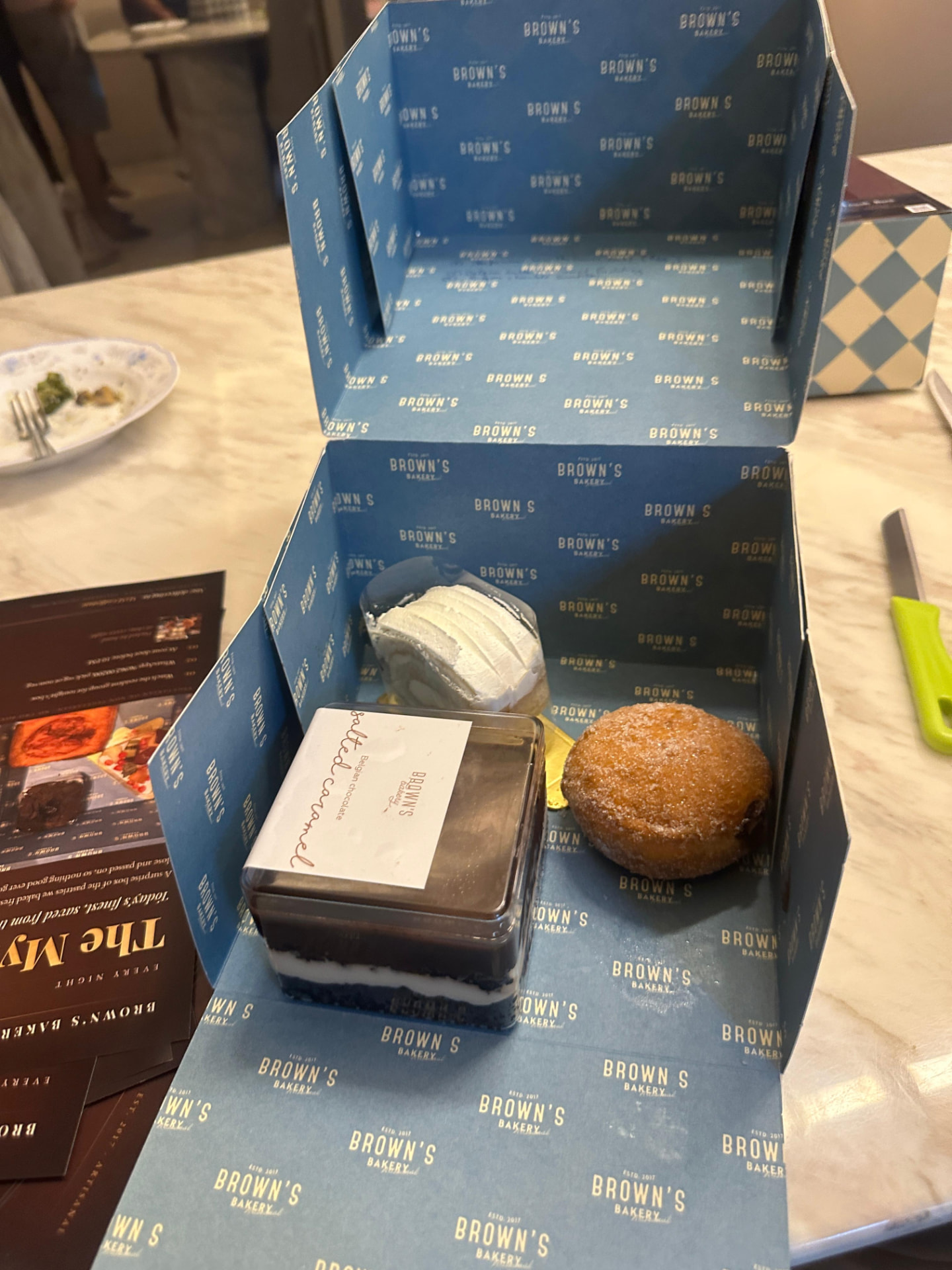 Salted caramel Belgian chocolate jar, cream roll and sugared doughnut in a Brown's Bakery box
