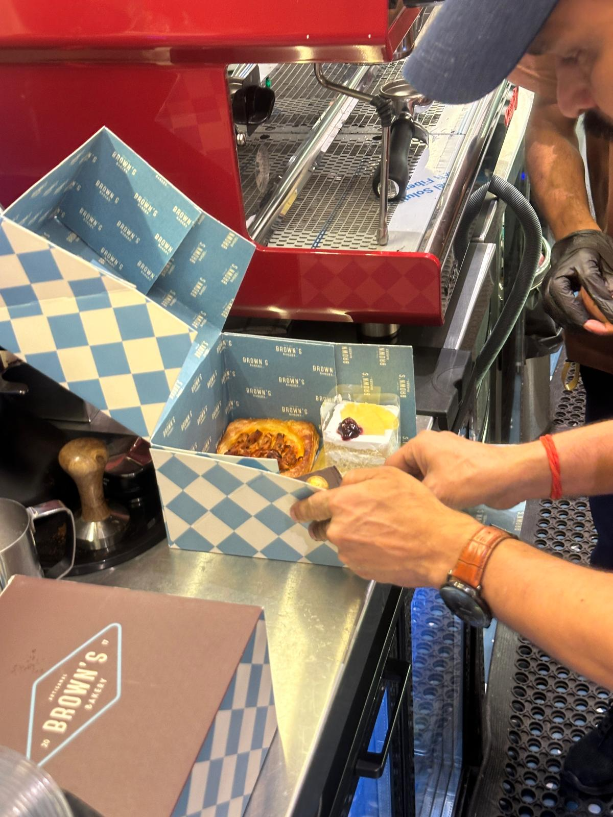 Pastries being placed into a Brown's Bakery box before delivery