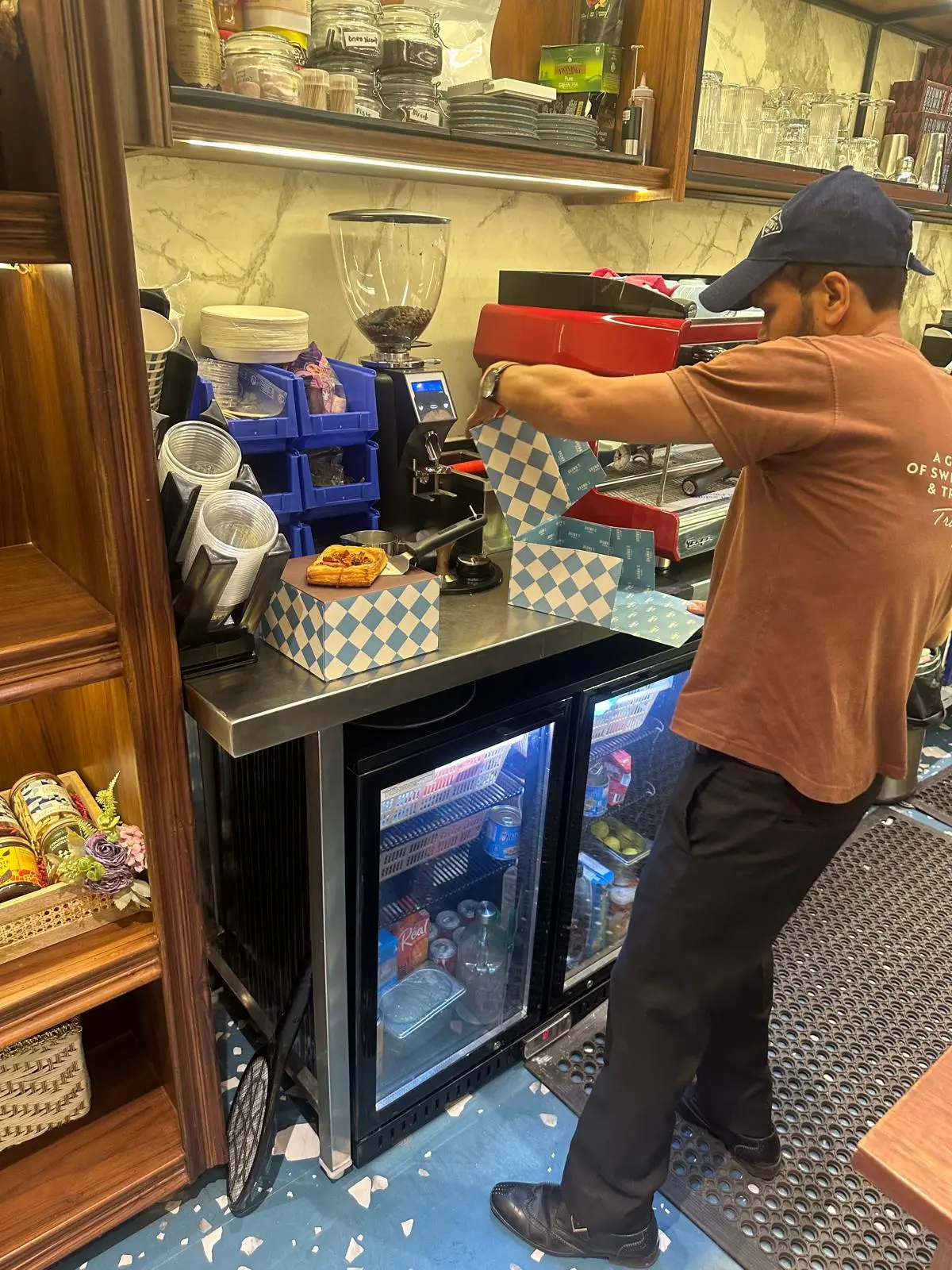 A Brown's Bakery staff member folding a mystery box at the counter